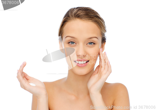 Image of happy young woman applying cream to her face