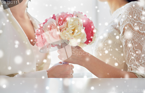 Image of close up of happy lesbian couple with flowers