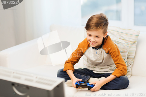 Image of happy boy with joystick playing video game at home