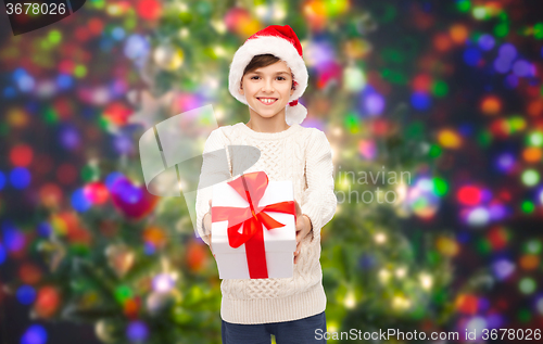 Image of smiling happy boy in santa hat with gift box