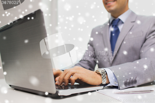 Image of close up of businessman with laptop and papers