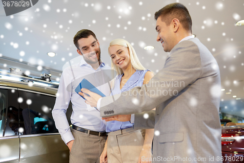 Image of happy couple with car dealer in auto show or salon