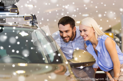 Image of happy couple buying car in auto show or salon