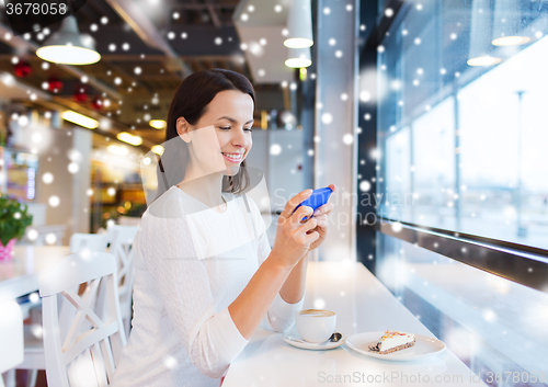 Image of smiling woman with smartphone and coffee at cafe