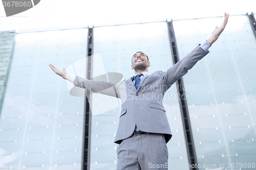 Image of young smiling businessman over office building
