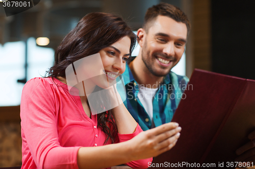 Image of smiling couple with menus at restaurant