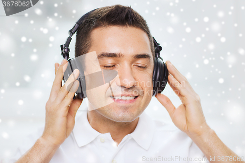 Image of happy man in headphones listening to music at home