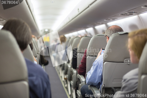 Image of Stewardessand passengers on commercial airplane.