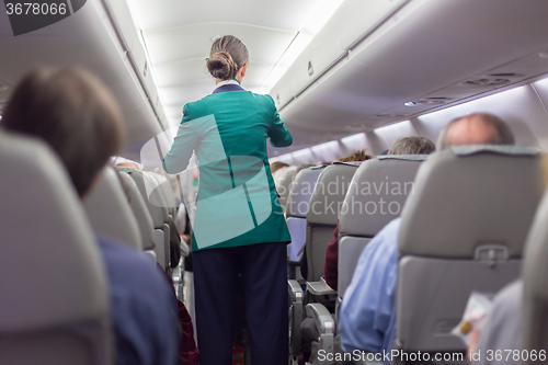 Image of Stewardessand passengers on commercial airplane.