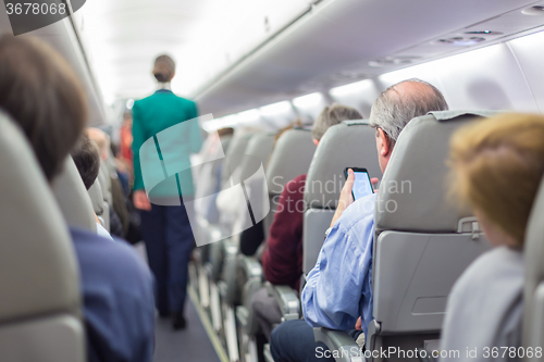 Image of Stewardessand passengers on commercial airplane.