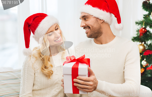 Image of happy couple at home with christmas gift box