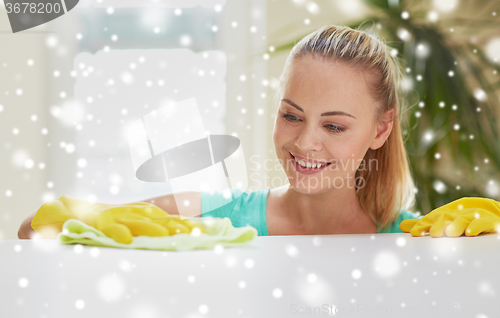 Image of happy woman cleaning table at home kitchen