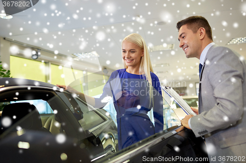 Image of happy woman with car dealer in auto show or salon