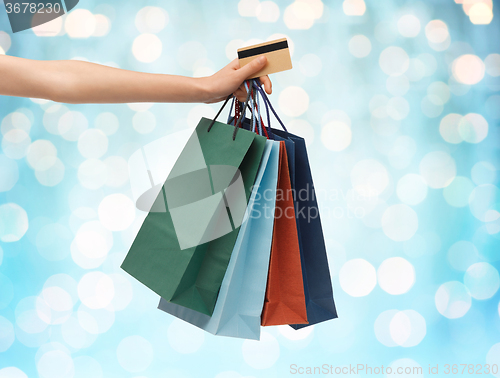Image of close up of woman with shopping bags and bank card