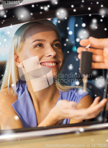 Image of happy woman getting car key in auto show or salon