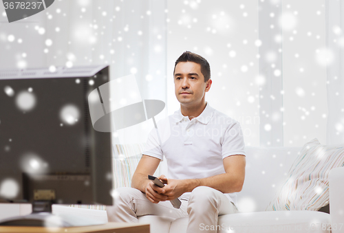 Image of man with remote control watching tv