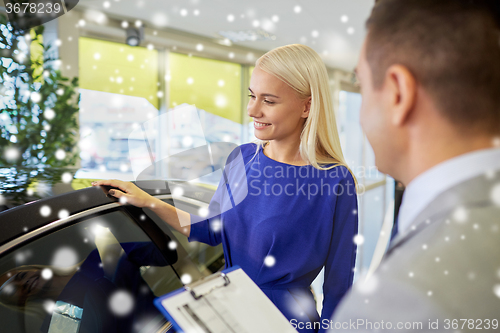 Image of happy woman with car dealer in auto show or salon