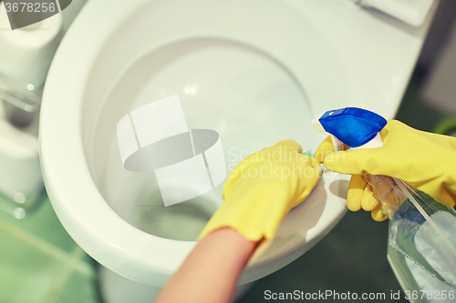 Image of close up of hand with detergent cleaning toilet