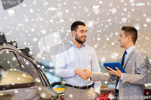 Image of happy man shaking hands in auto show or salon