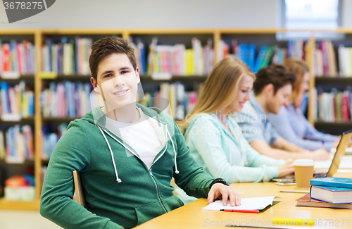 Image of happy student boy reading books in library