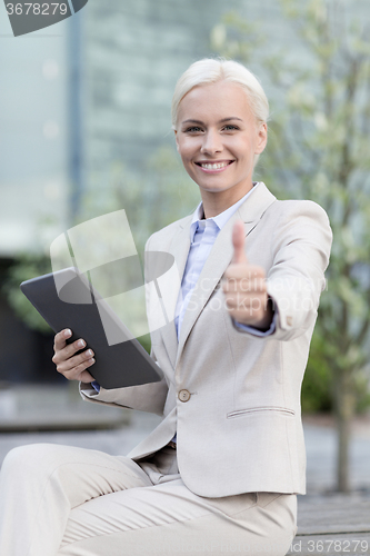 Image of smiling businesswoman with tablet pc outdoors