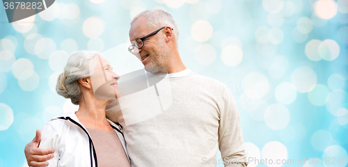 Image of happy senior couple over blue holidays lights