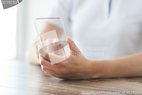 Image of close up of woman with transparent smartphone