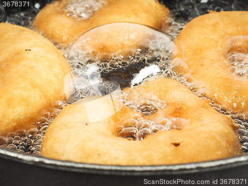 Image of Closeup of donuts cooking in boiling oil in kettle
