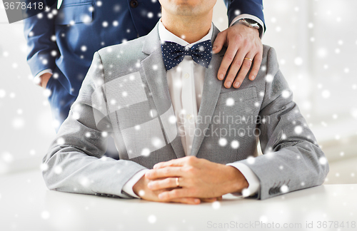 Image of close up of male gay couple with wedding rings on