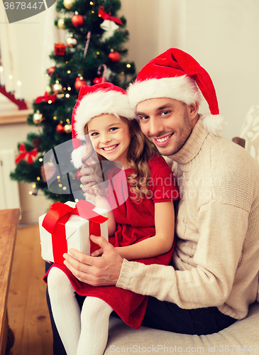 Image of smiling father and daughter holding gift box