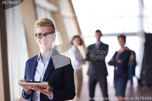 Image of business woman  at office with tablet  in front  as team leader