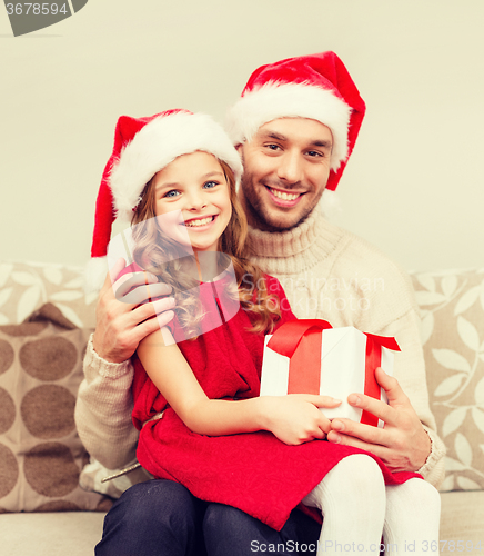 Image of smiling father and daughter holding gift box