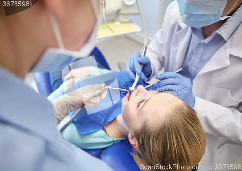 Image of close up of dentist treating female patient teeth