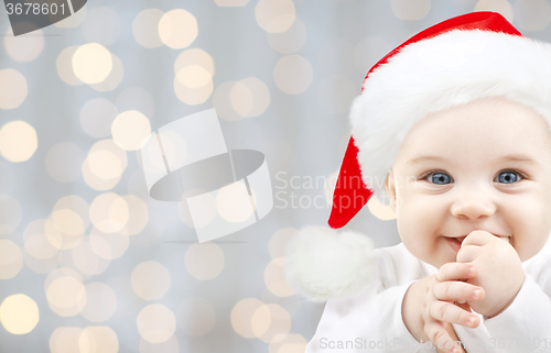 Image of happy baby in santa hat over holidays lights