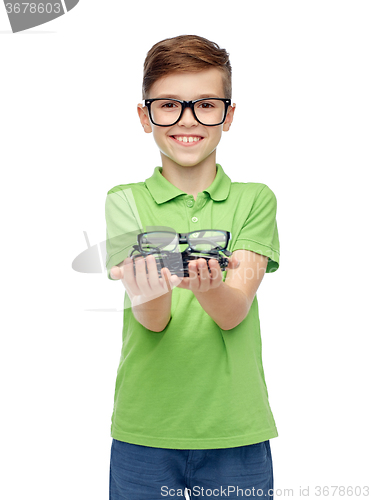 Image of happy boy in green polo t-shirt holding eyeglasses