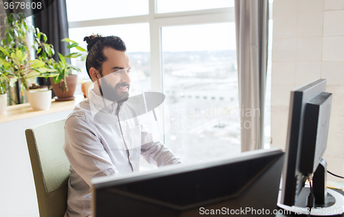 Image of happy creative male office worker with computer