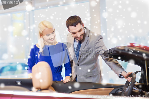 Image of happy couple buying car in auto show or salon