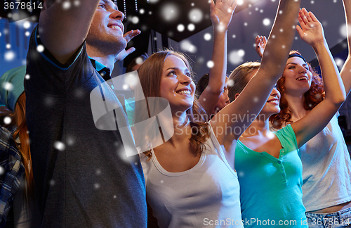 Image of smiling friends at concert in club