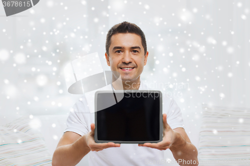 Image of smiling man showing tablet pc blank screen at home