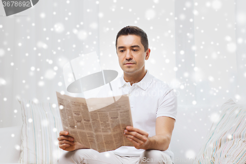 Image of man reading newspaper at home