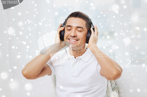 Image of happy man in headphones listening to music at home