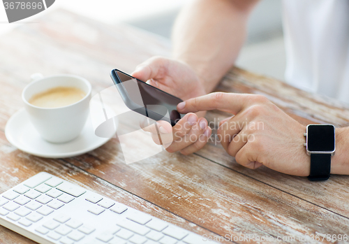 Image of close up of hands with smart phone and watch