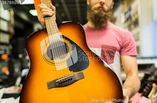 Image of close up of man with guitar at music store