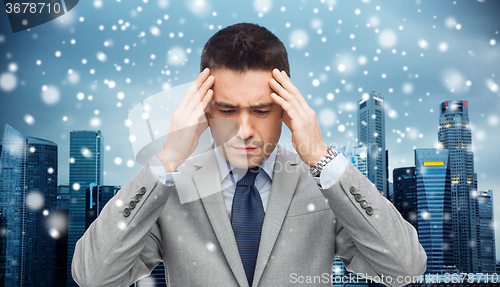 Image of businessman in suit having head ache