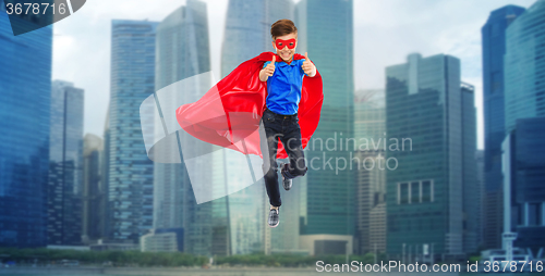 Image of boy in super hero cape and mask showing thumbs up