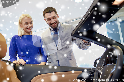 Image of happy couple buying car in auto show or salon