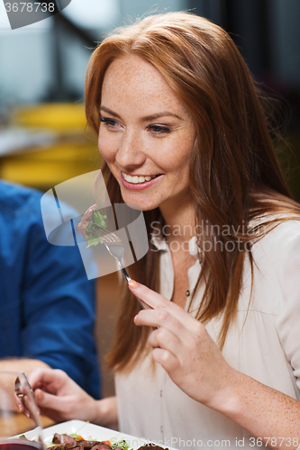 Image of happy woman having dinner at restaurant