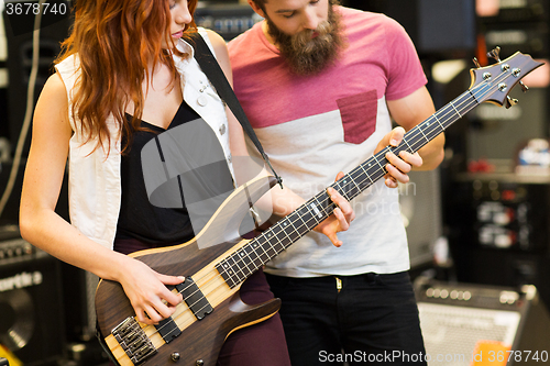 Image of couple of musicians with guitar at music store