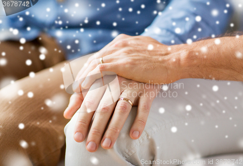 Image of close up of happy male gay couple holding hands