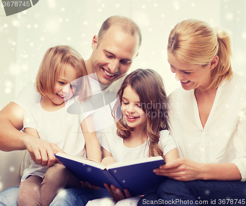 Image of happy family with book at home